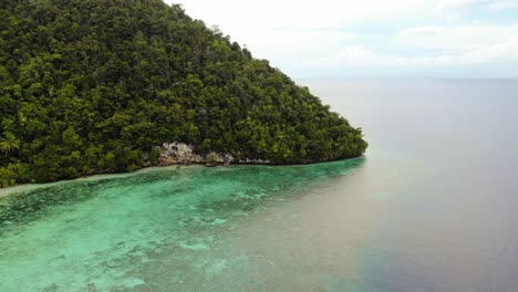 Aerial-view-of-Kri-Island's-coastline-in-Raja-Ampat,-Indonesia,-captured-by-a-drone-moving-forward