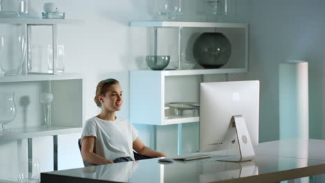 smiling businesswoman talking online with friend leaning chair after hard day.