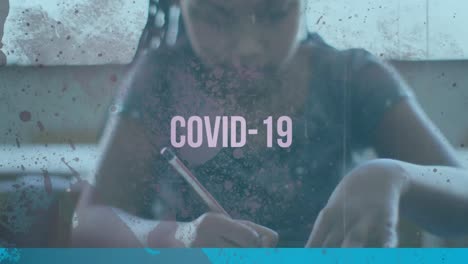 Animation-Des-Wortes-„Covid-19“-über-Einem-Mädchen,-Das-Im-Klassenzimmer-Sitzt-Und-Schreibt