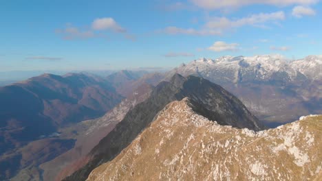 flying low over mountain ridge revealing top of mountain with three hikers