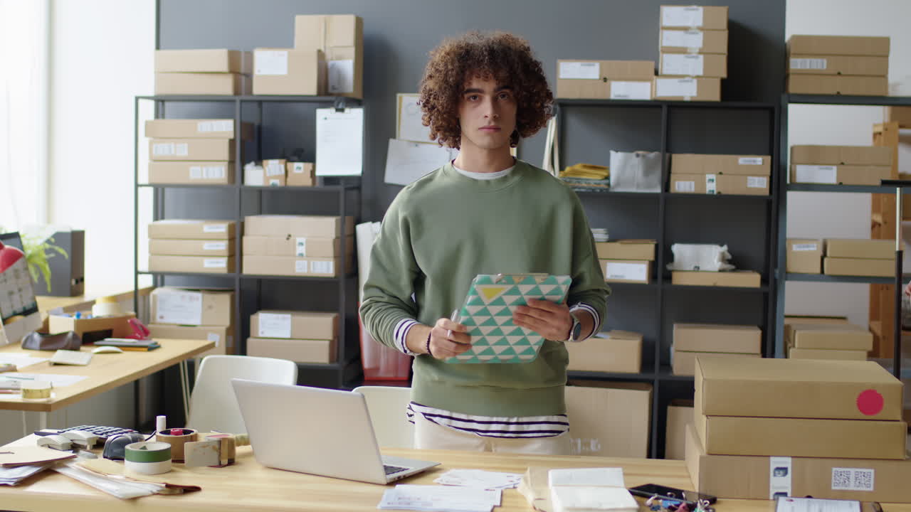 Man in warehouse with boxes and laptop