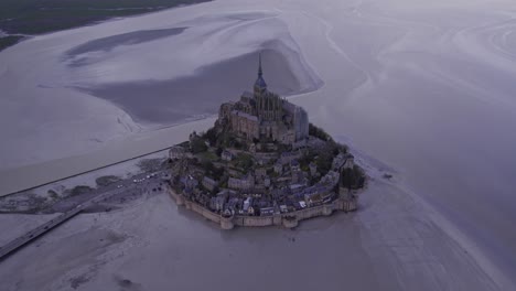 The-famous-Mont-Saint-Michel-at-low-tide-with-clouds,-aerial