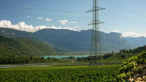 hermoso paisaje natural de campos agrícolas, lago kalterer y montañas en el fondo durante el día soleado en italia