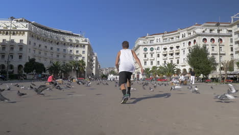 Joven-Haciendo-Bóveda-En-La-Plaza-Con-Palomas