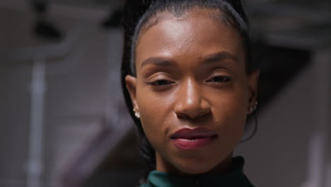 close up portrait of determined female athlete zipping up tracksuit training in gym preparing for sports event or exercise