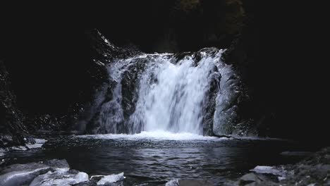 waterfall in narrow ravine dropping into pool