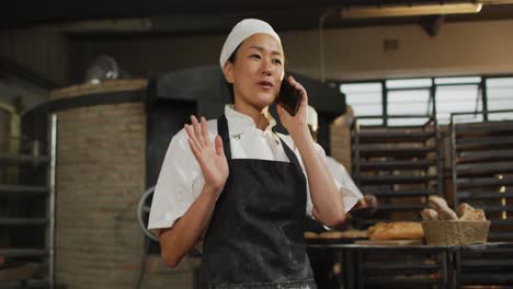 animation of happy asian female baker having call