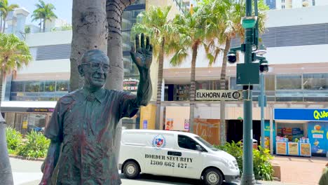 statue near busy street with passing vehicles