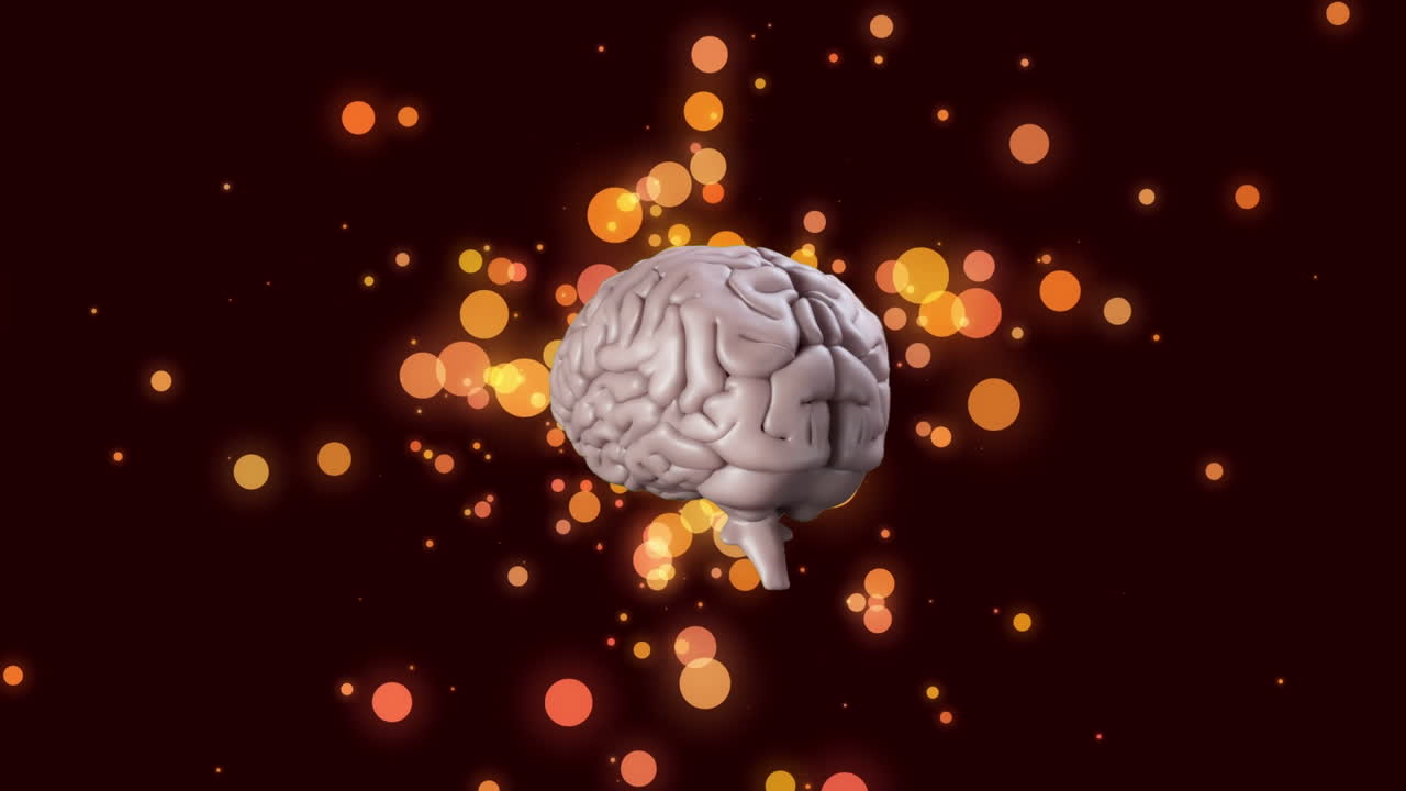 icono del cerebro humano girando sobre manchas de luz naranja flotando contra un fondo negro