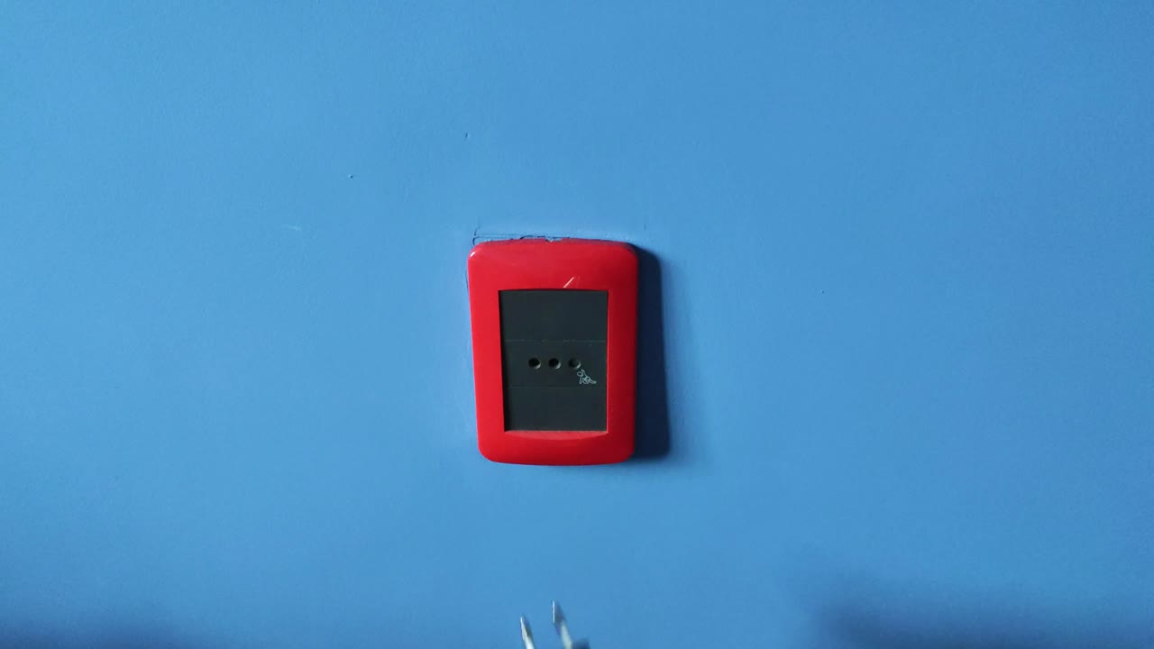 hombre blanco en la pared azul desconectando un cable