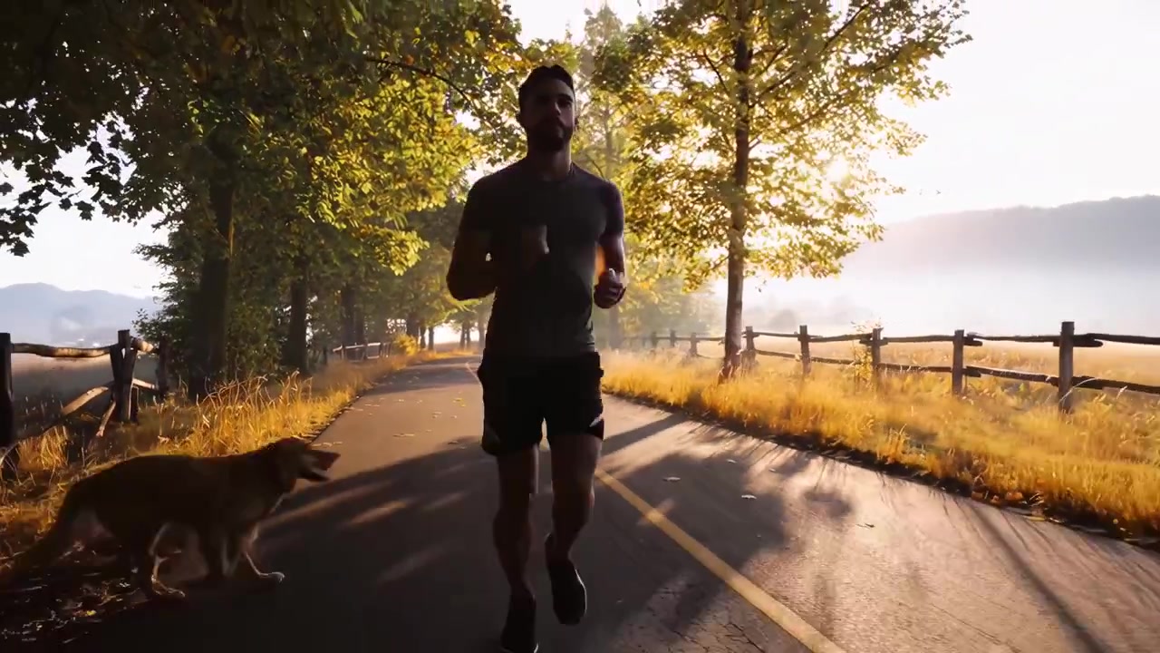 Giovane uomo che fa jogging con il suo cane su una strada di campagna all'alba