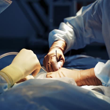 operating process under medical lamp. surgeons' hands in gloves perform an operation on a patient with medical tools. close-up.