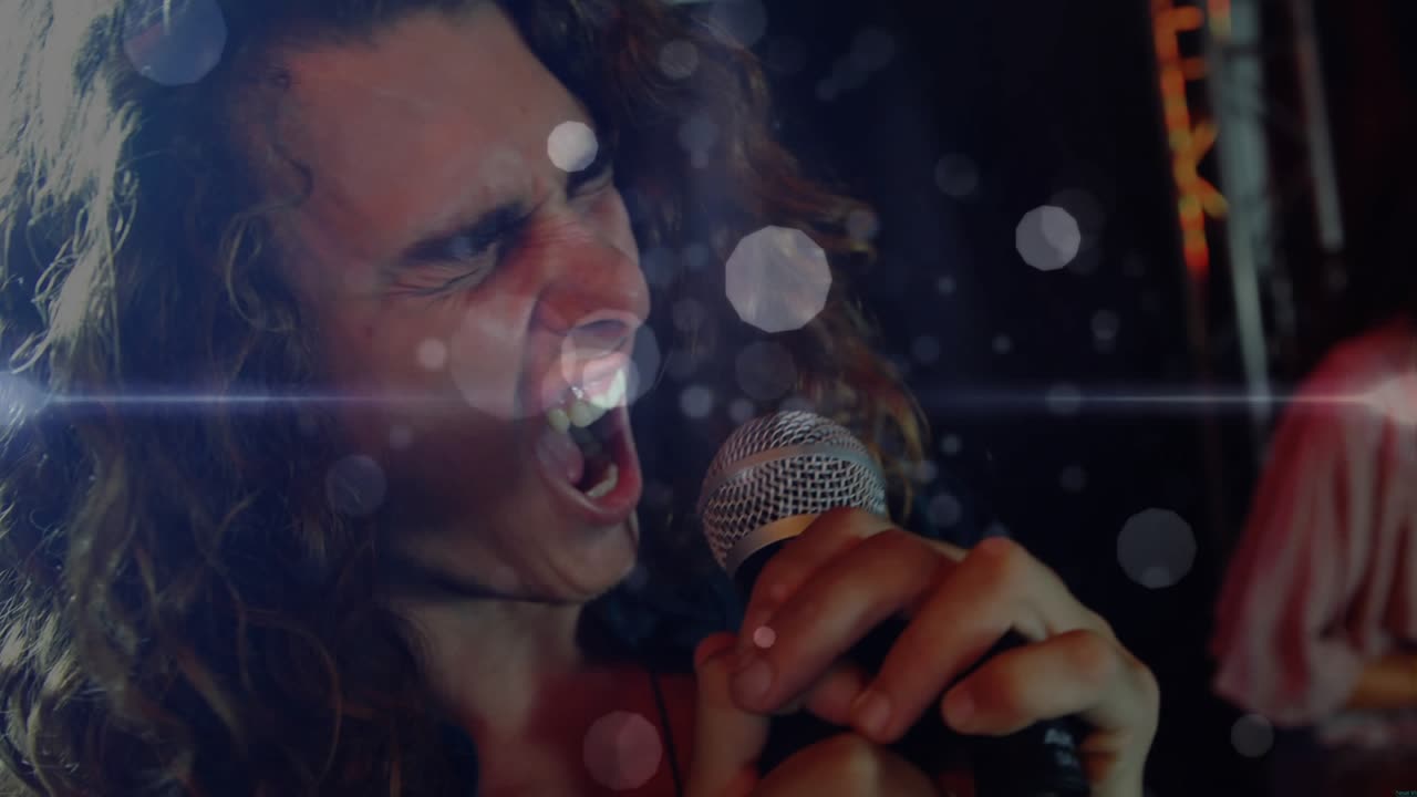 Vocalist gripping mic and delivering vocals, swaying under lens flares driving music collaboration