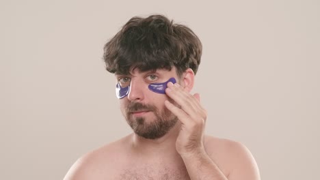 man applying eye patches