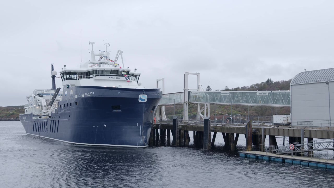 Inquadratura statica di una nave per l'acquacoltura ormeggiata in porto. Ripresa vicino a Stornoway sull'isola di Lewis, parte delle Ebridi Esterne della Scozia.