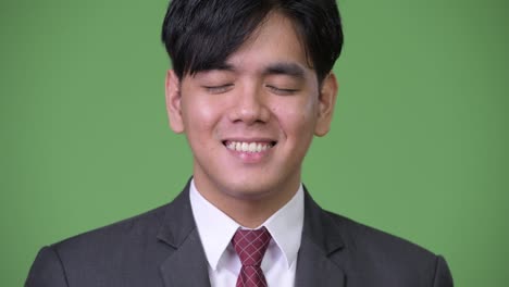 젊은 잘생긴 아시아 사업가 눈을 감고 휴식을 취하고 있습니다.