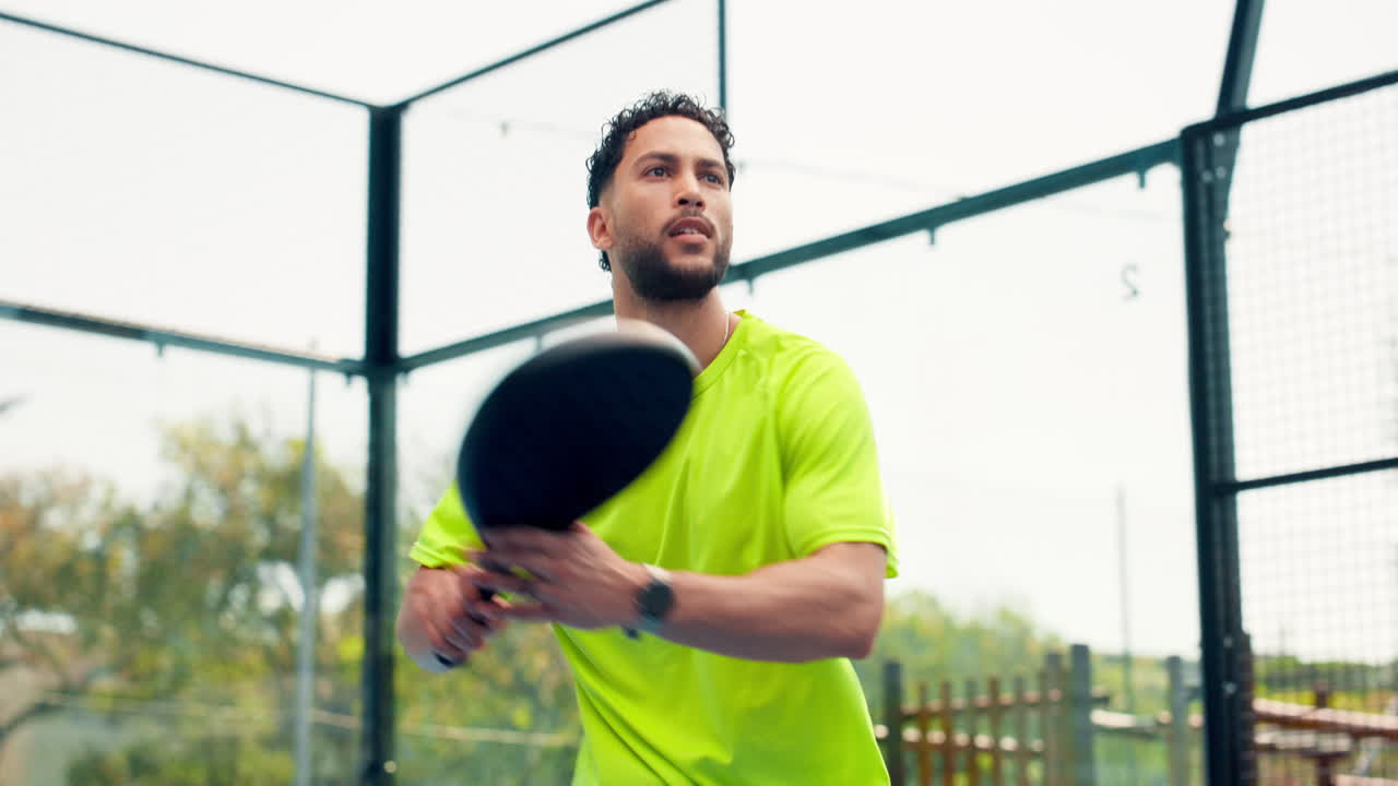 Uomo concentrato che gioca a padel su un campo all'aperto