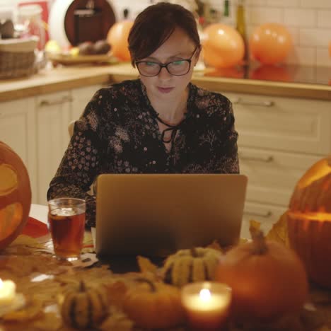 Frau-Mit-Laptop-Inmitten-Von-Halloween-Dekorationen