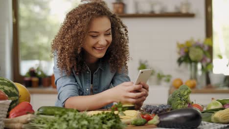 mujer joven usando teléfono móvil en la cocina/rzeszow/polonia