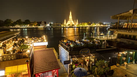 night view of wat arun and riverfront restaurants in bangkok