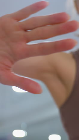 close-up of woman giving a high five to a friend in a bright fitness environment, capturing enthusiasm, teamwork, motivation, and support during a workout session