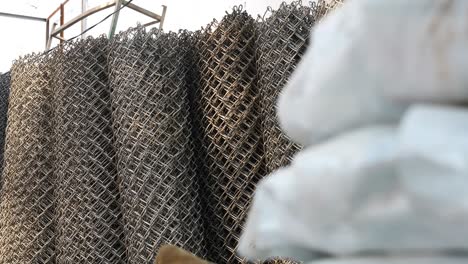 Rolls-Of-Heavy-Duty-Wire-Mesh-Rolls-Stacked-Next-To-Each-Other,-Dolly-Reveal,-Low-Angle