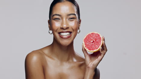 woman holding grapefruit