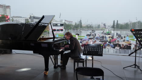 pianist performing outdoors in the rain