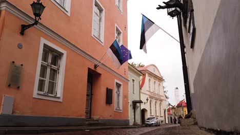 estonia and european union flags are waving on small tallinn's downtown alley on a windy autumn day