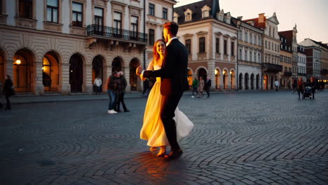 couple dancing in a city square at sunset