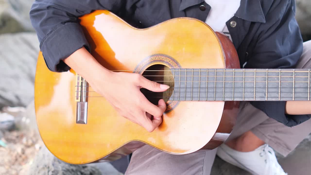 인도네시아 청소년 이 기타 를 연주 하고 있다