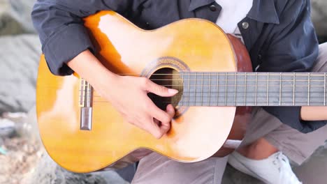 un joven indonesio tocando la guitarra