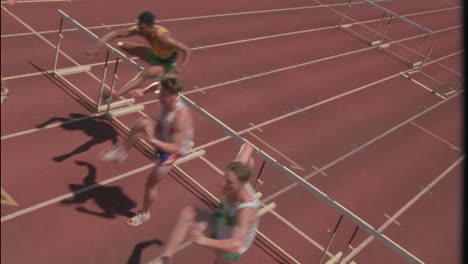 a group of racers jump over hurdles