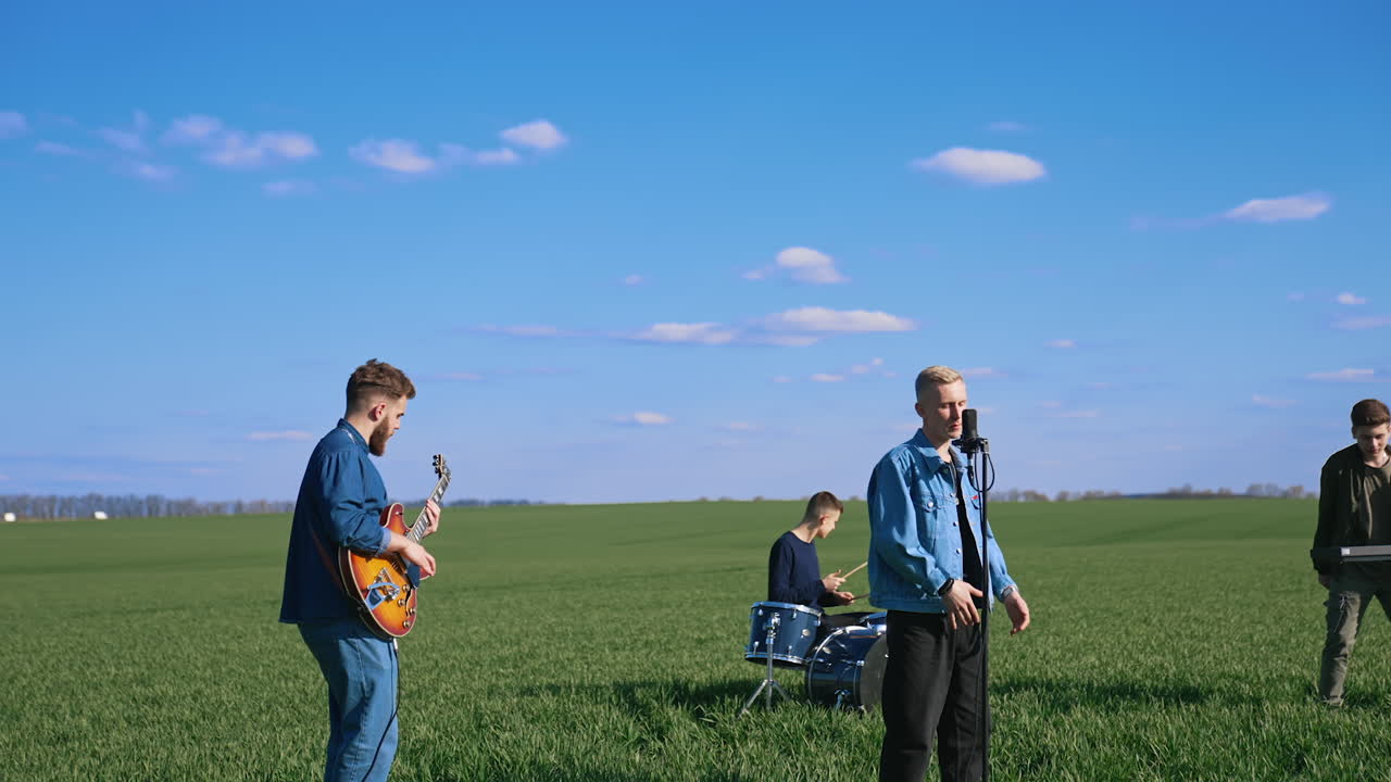 Musical band on field. Young musical band performing concert on nature
