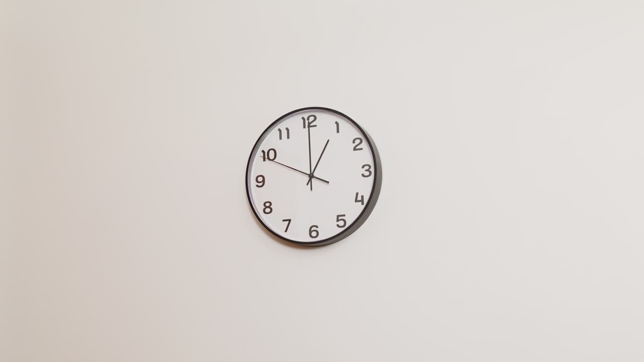 Un orologio da parete in bianco e nero dall'aspetto professionale e aziendale, montato su una superficie bianca liscia e che segna l'una.