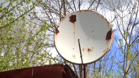 large rusty satellite dish on the roof of the house