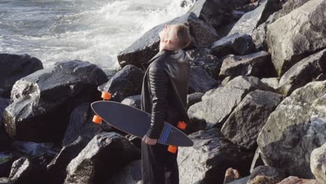 young man with longboard looks up