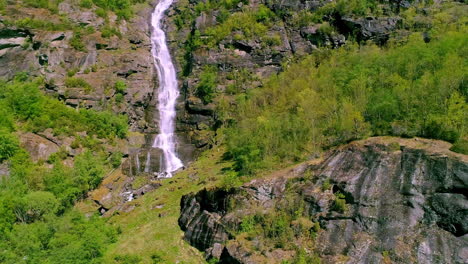 waterfall on a cliff in a mountain forest - aerial view