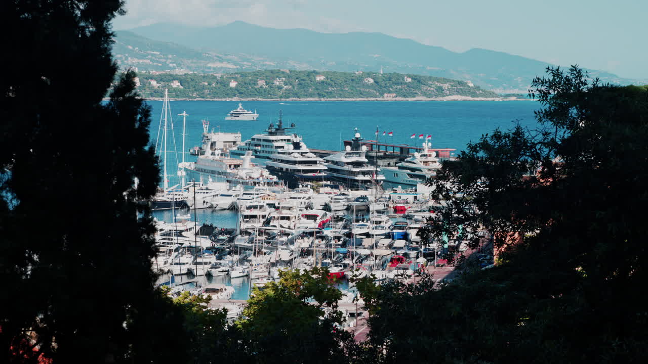 Vista aerea delle barche ormeggiate nel porto turistico di Monaco, con lo skyline della città sullo sfondo