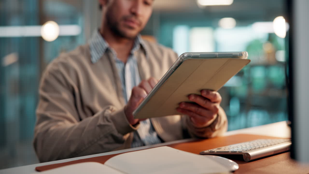 Man Tapping and Scrolling on Digital Tablet in Modern Office