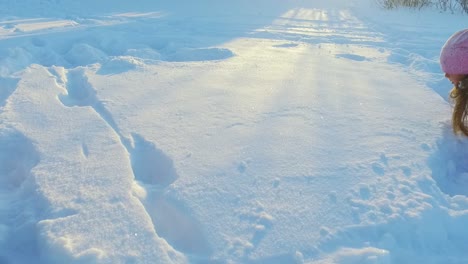 Kleines-Mädchen,-Das-Spaß-Hat-Und-In-Zeitlupe-Auf-Schnee-Liegt.-Wintertraum