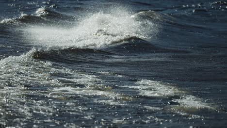 long white-crested waves crash onto the pebble beach