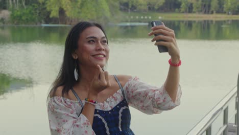woman taking selfie by the lake