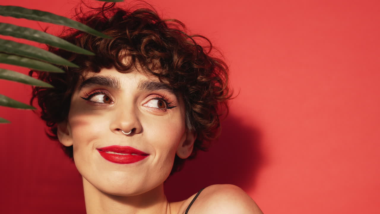 Donna con capelli ricci e una foglia tropicale
