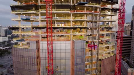 aerial view in front of a high-rise construction site, sunrise in houston, usa - ascending, drone shot