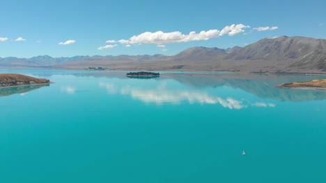 뉴질랜드 테카포 호수(lake tekapo)의 공중 전망, 화창한 날 호수 위에 카메라 팬