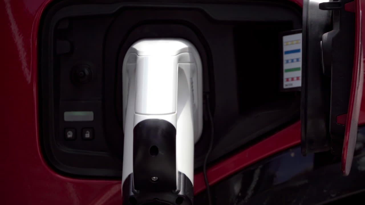 Close up of a red, electric car charging