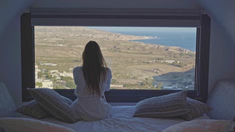 Una-Joven-Contempla-El-Futuro-Mirando-Por-La-Ventana-Con-Una-Hermosa-Vista-Al-Hotel-Costero.