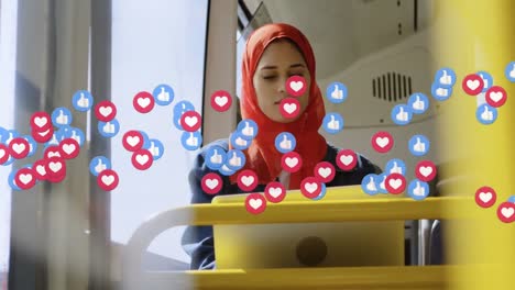 animation of falling social media icons over woman in hijab using laptop