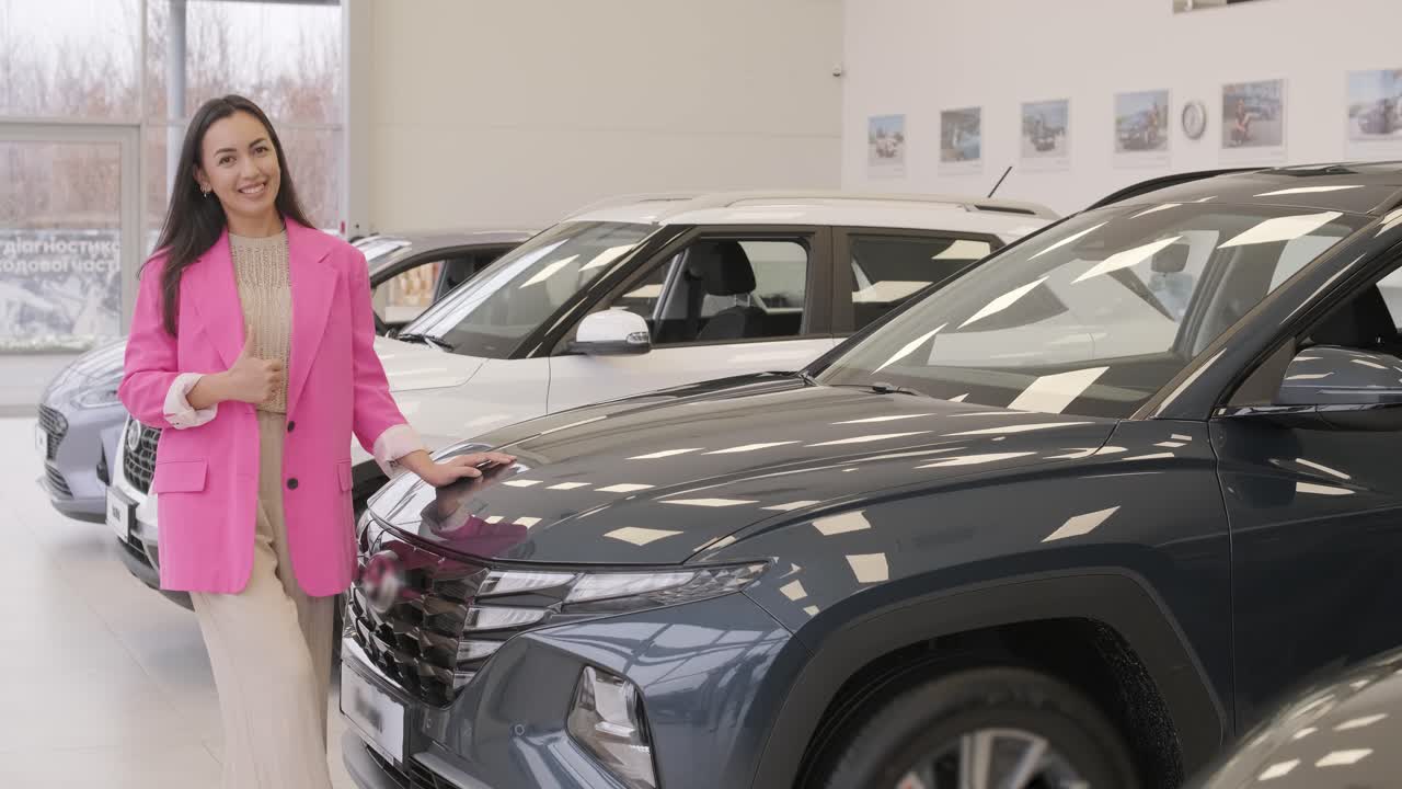 mujer eligiendo un coche en una sala de exposición de automóviles